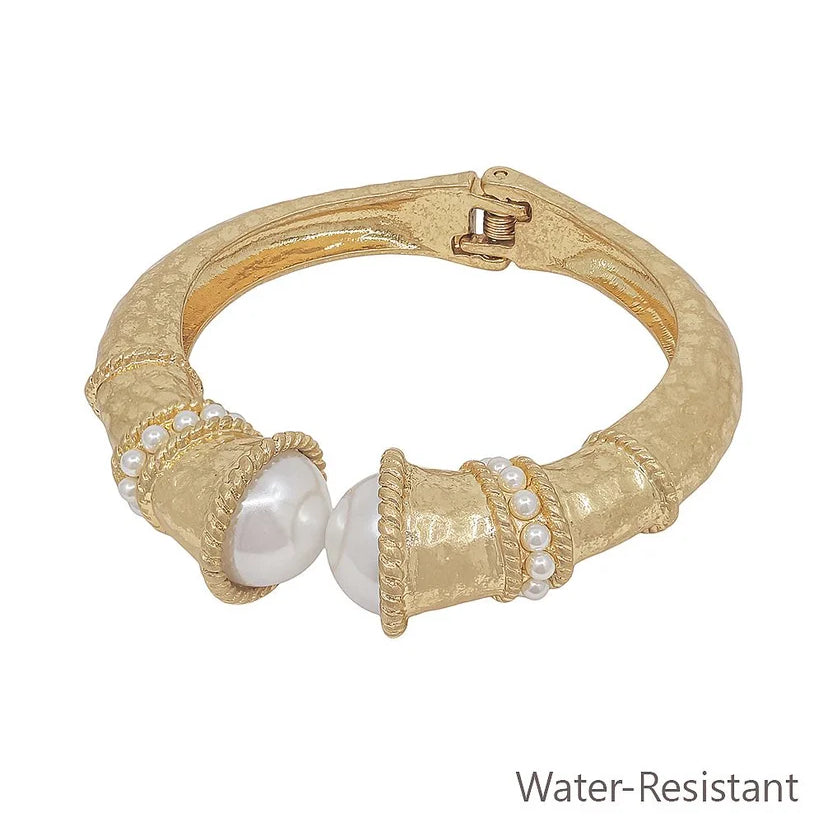 Gold bracelet with pearls on a white background