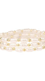 Set of pearl and gold beaded bracelets on a white background