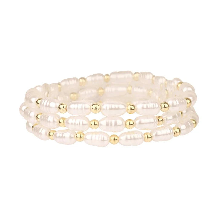 Set of pearl and gold beaded bracelets on a white background