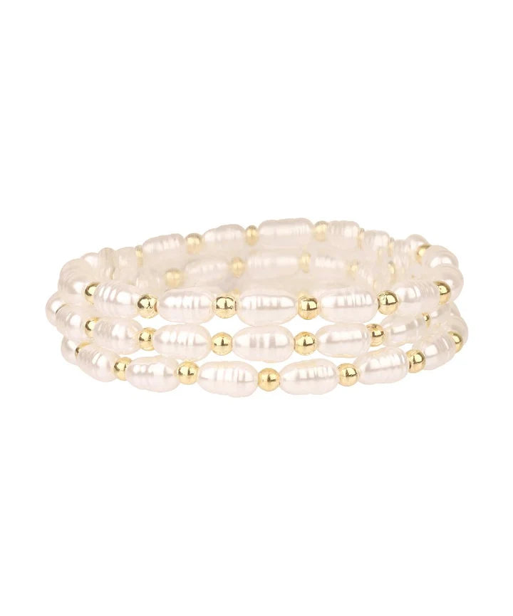 Set of pearl and gold beaded bracelets on a white background