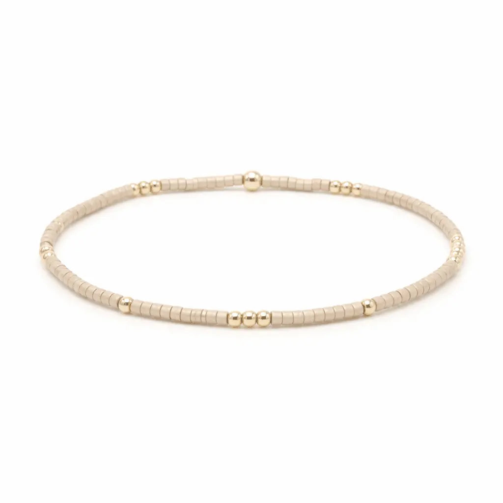 Gold beaded necklace on a white background