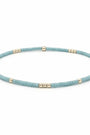 A beaded stretch bracelet featuring textured light blue beads separated by small metallic gold spacer beads, displayed on a clean white background.