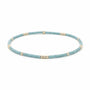 A beaded stretch bracelet featuring textured light blue beads separated by small metallic gold spacer beads, displayed on a clean white background.