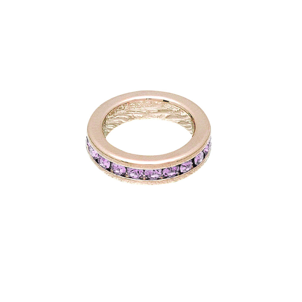 Gold ring with purple gemstones on a white background
