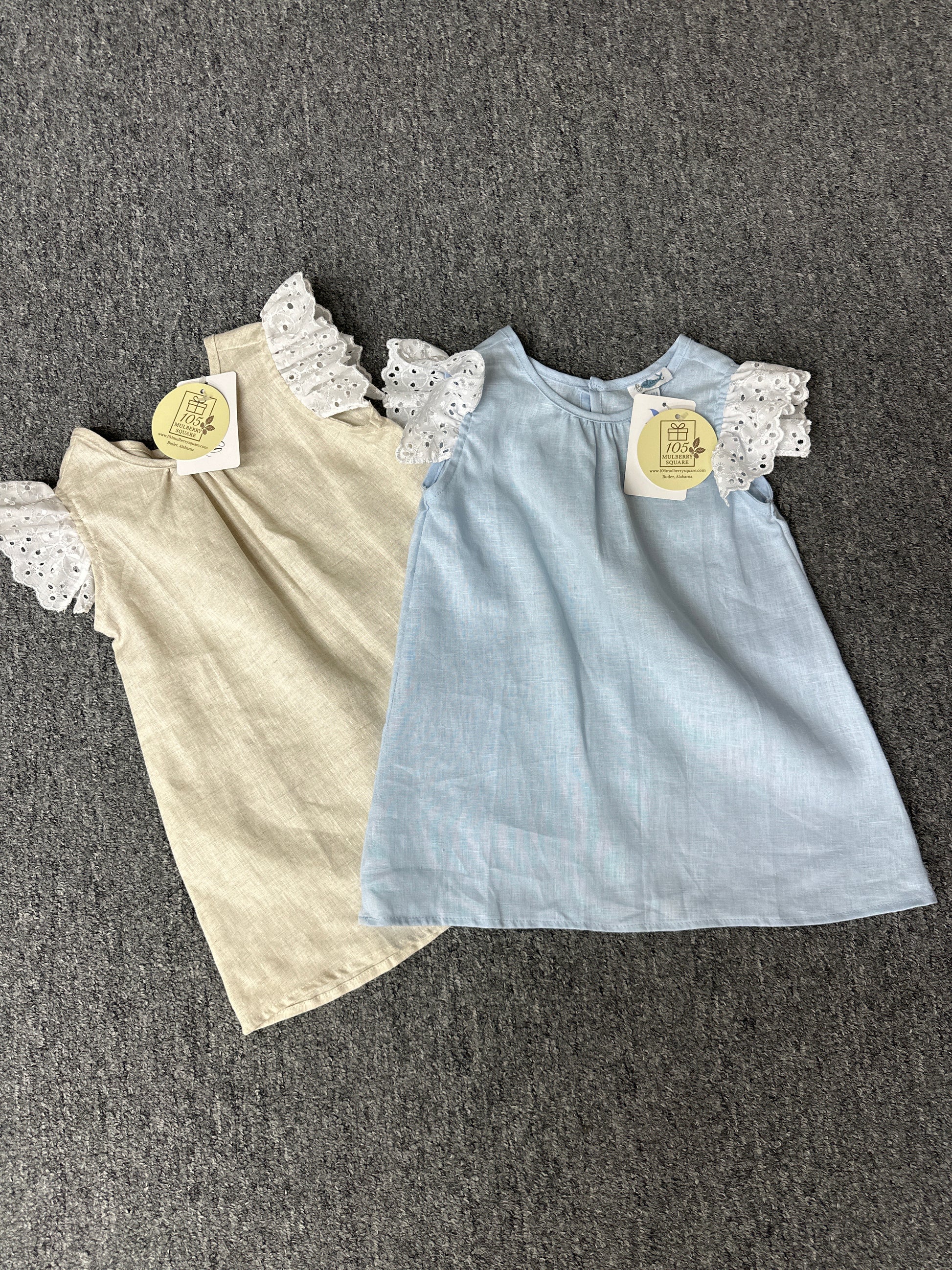 Children's outfit with a blue top and beige skirt on a gray background