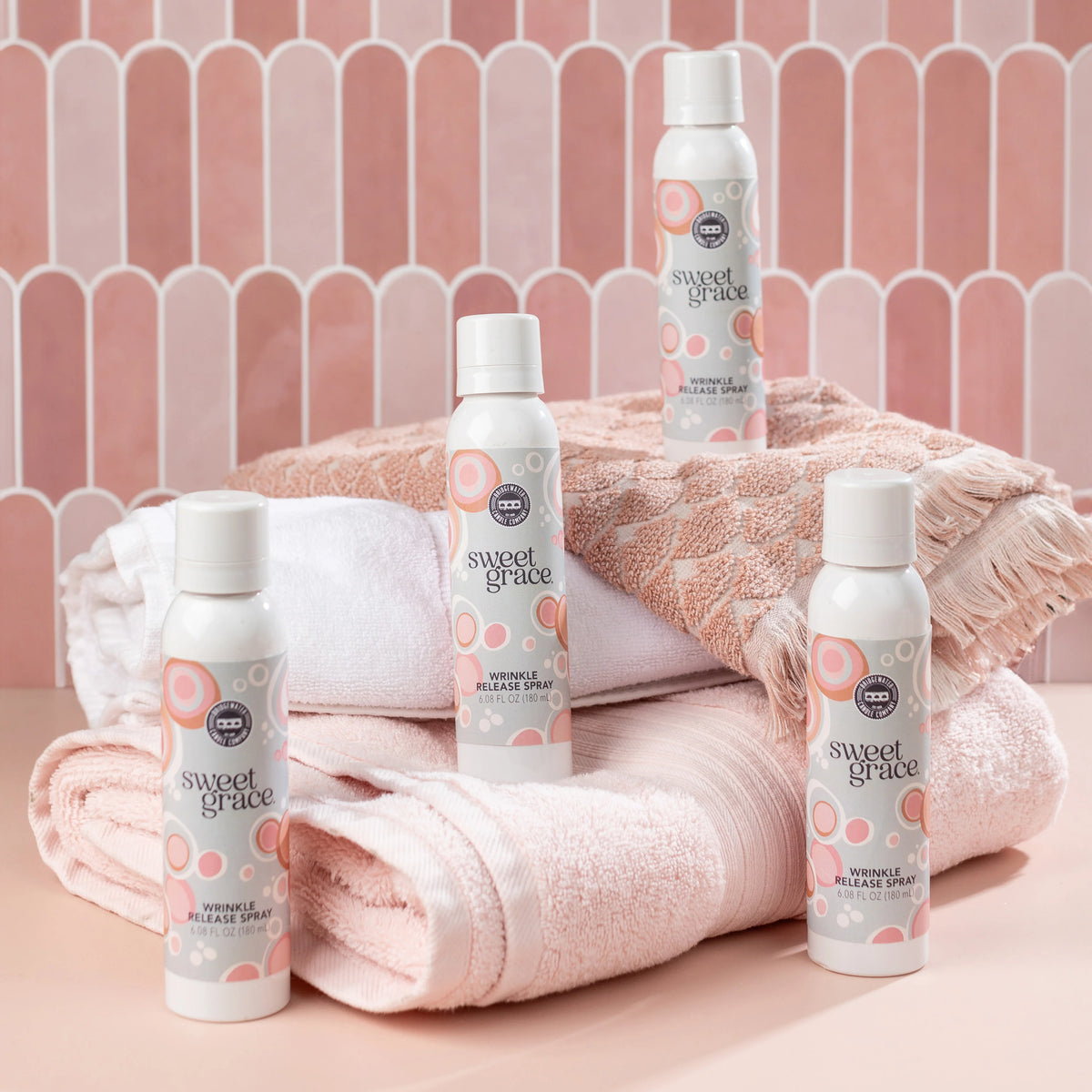 Wrinkle release spray bottles with Sweet Grace labels and folded towels