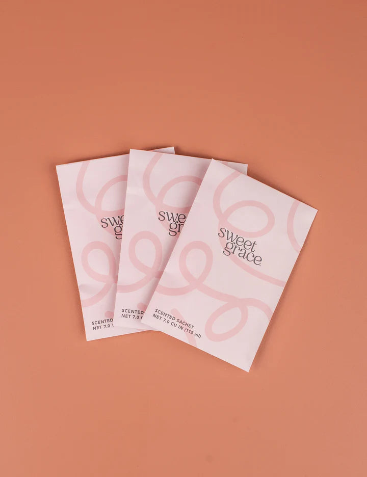 Three 'sweet grace' product packages on a brown background