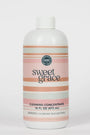 A 16 fl oz bottle of Sweet Grace Cleaning Concentrate with a white cap and a label featuring horizontal stripes in pink, peach, and light gray on a white background.