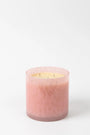 Pink candle in a glass container on a white background
