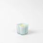 Iridescent candle holder with a candle inside on a white background
