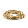 Gold beaded bracelet on a white background