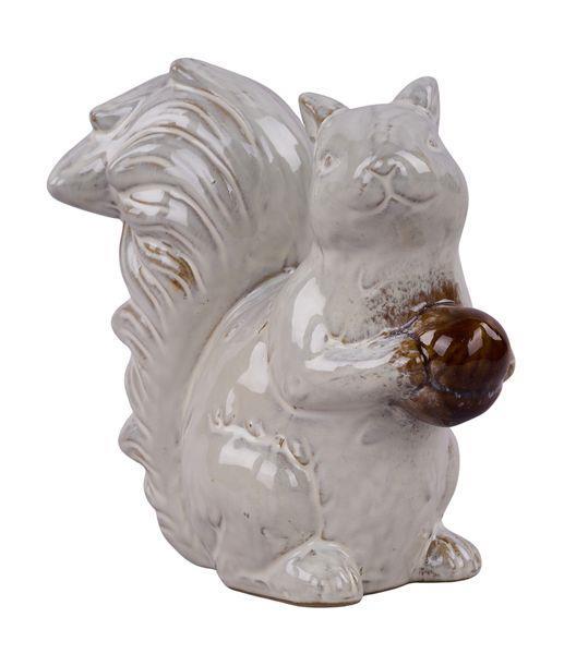 White ceramic squirrel figurine with a brown nut on a white background
