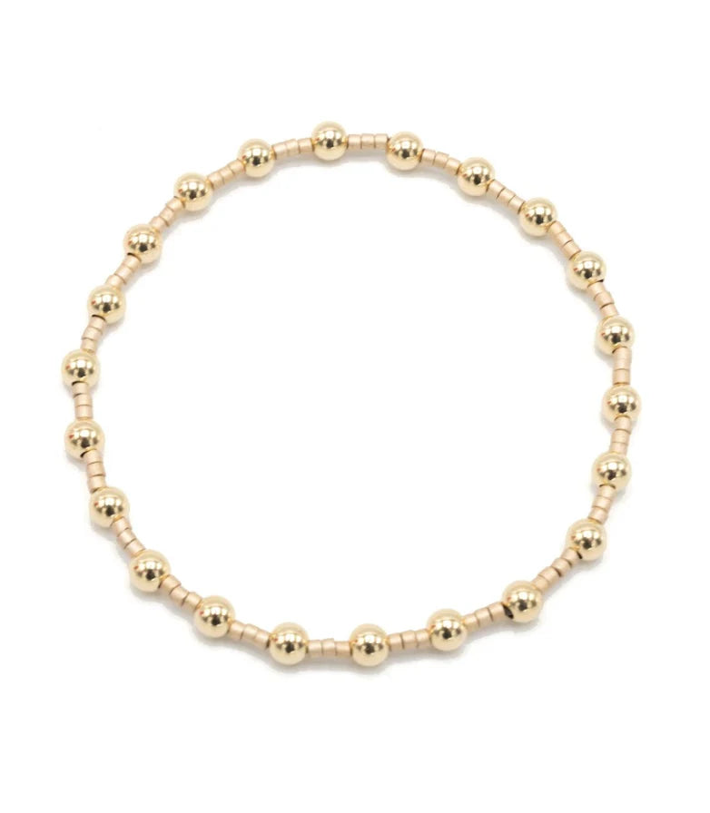 Gold beaded bracelet on a white background