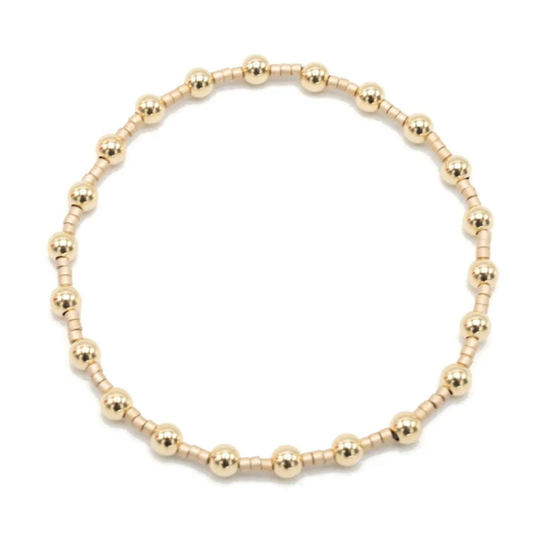 Gold beaded bracelet on a white background