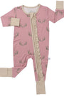 A baby's pink footed sleeper with a subtle pattern of small cartoon characters, featuring beige cuffs and a beige zipper closure down the front.