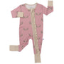 A baby's pink footed sleeper with a subtle pattern of small cartoon characters, featuring beige cuffs and a beige zipper closure down the front.