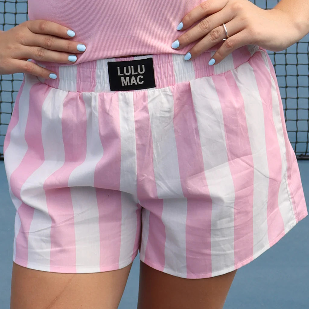 Pink and white striped shorts with 'LULU MAC' label, worn by a person.