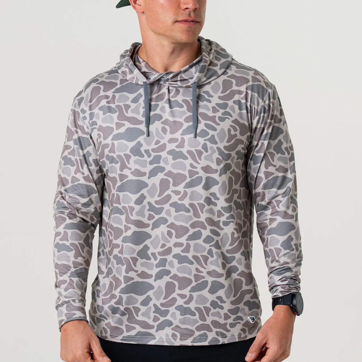 Person wearing a camouflage-patterned hoodie on a plain background