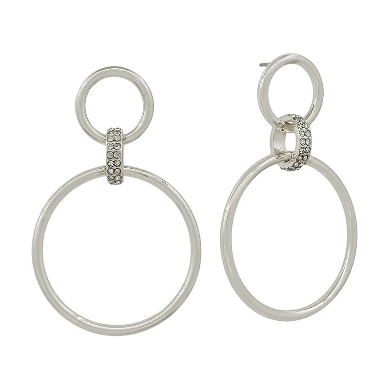 A pair of silver-tone drop earrings featuring a small circular hoop connected to a larger oval drop, with a small pavé-set accent between the hoops, shown on a plain white background.