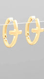 Gold hoop earrings with cross designs on a gray background
