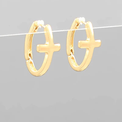 Gold hoop earrings with cross designs on a gray background