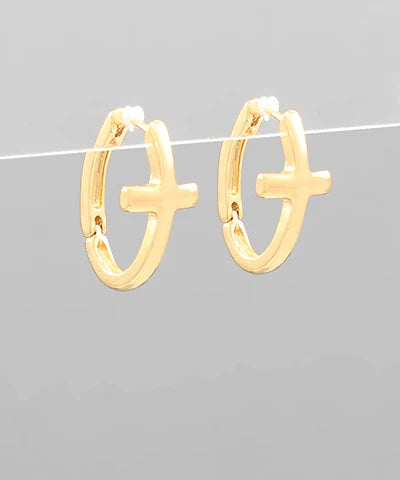 Gold hoop earrings with cross designs on a gray background