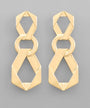 A pair of gold geometric drop earrings with interlocking circular and angular links, displayed on a neutral gray background.