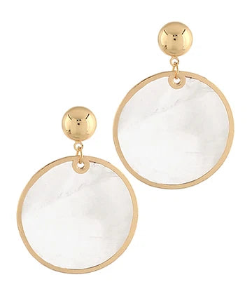 A pair of gold-tone drop earrings featuring large circular clear resin pendants with a subtle white marble pattern, suspended from polished gold ball studs.