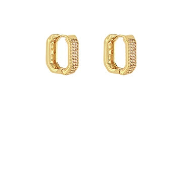 A pair of gold huggie hoop earrings with pavé-set clear stones on the front, shown against a plain white background.