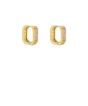 A pair of gold huggie hoop earrings with pavé-set clear stones on the front, shown against a plain white background.