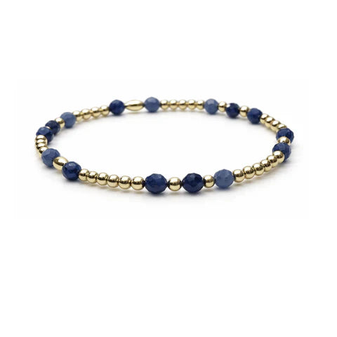 Bracelet with blue beads and gold accents on a white background