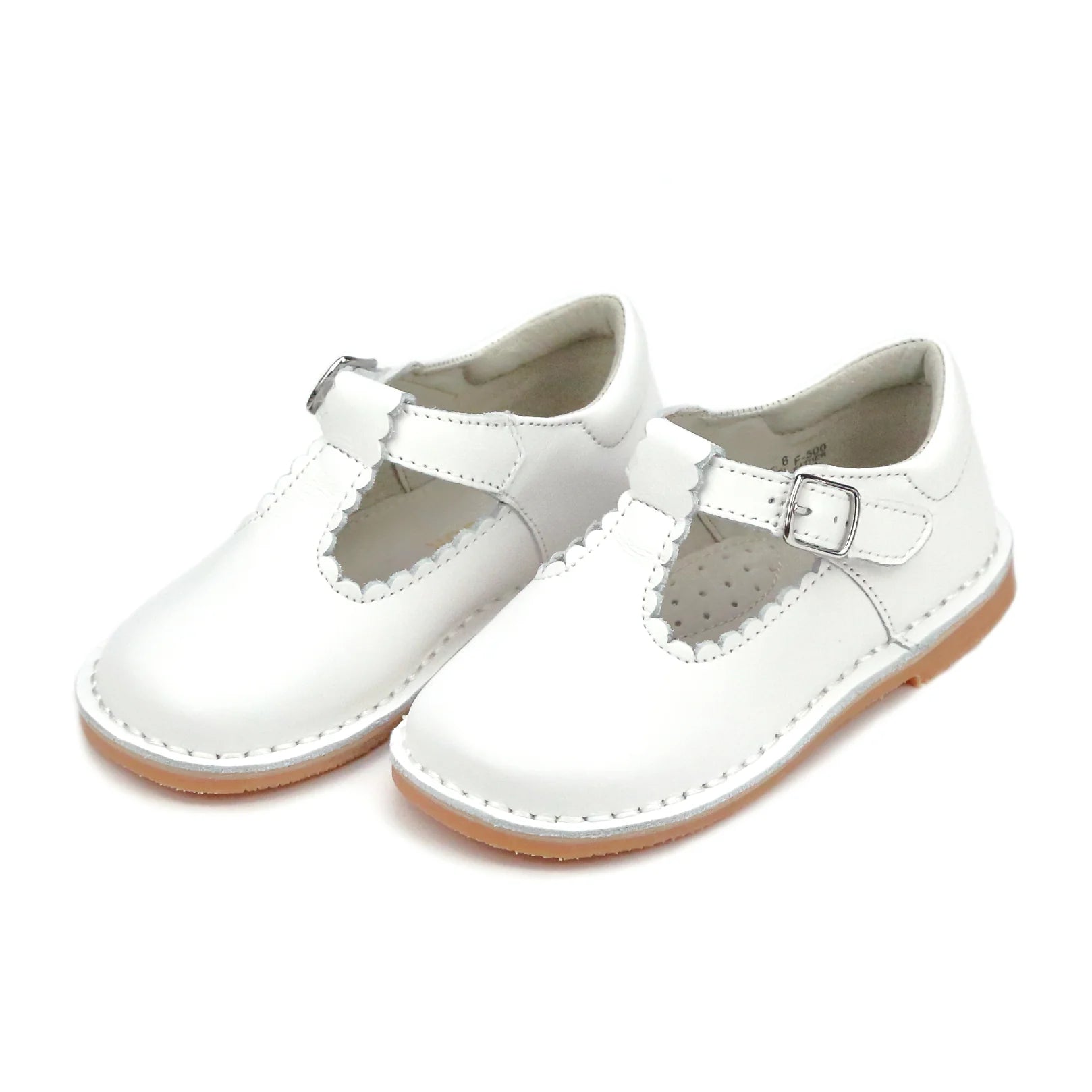 Pair of white children's shoes with buckles on a white background