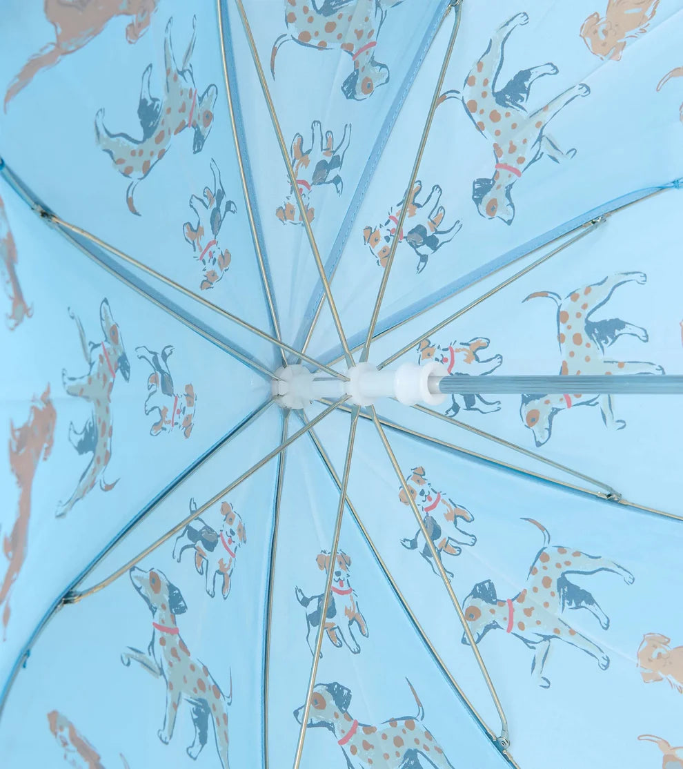 A light blue umbrella viewed from underneath, featuring a repeating pattern of Dalmatian dogs in orange spots and blue collars on a pale blue background.