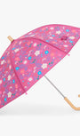 A pink umbrella with a colorful floral pattern, featuring a light wood handle and top cap, shown against a plain light gray background.