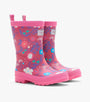 A pair of children's pink rubber rain boots with a colorful floral and abstract pattern, featuring pull tabs and a thick lug sole, shown on a light gray background.