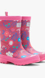 A pair of children's pink rubber rain boots with a colorful floral and abstract pattern, featuring pull tabs and a thick lug sole, shown on a light gray background.