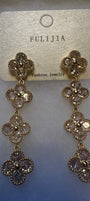 A pair of gold-tone dangle earrings with three floral clover motifs, each adorned with clear rhinestones, hanging from a textured beige card labeled 'FULIJIA'.