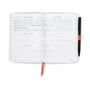 Open notebook with golf scorecard pages and a pen on a white background