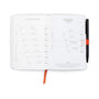 Open notebook with measurement charts and a pen on a white background