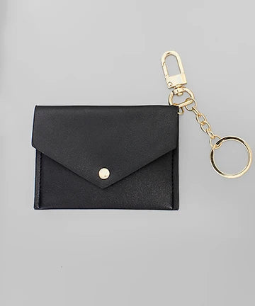 A black faux leather envelope-style card holder wallet with a gold-tone snap button, attached to a gold keychain clasp and split ring, shown on a neutral gray background.