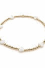 Bracelet with gold beads and white stones on a white background