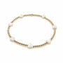 Bracelet with gold beads and white stones on a white background