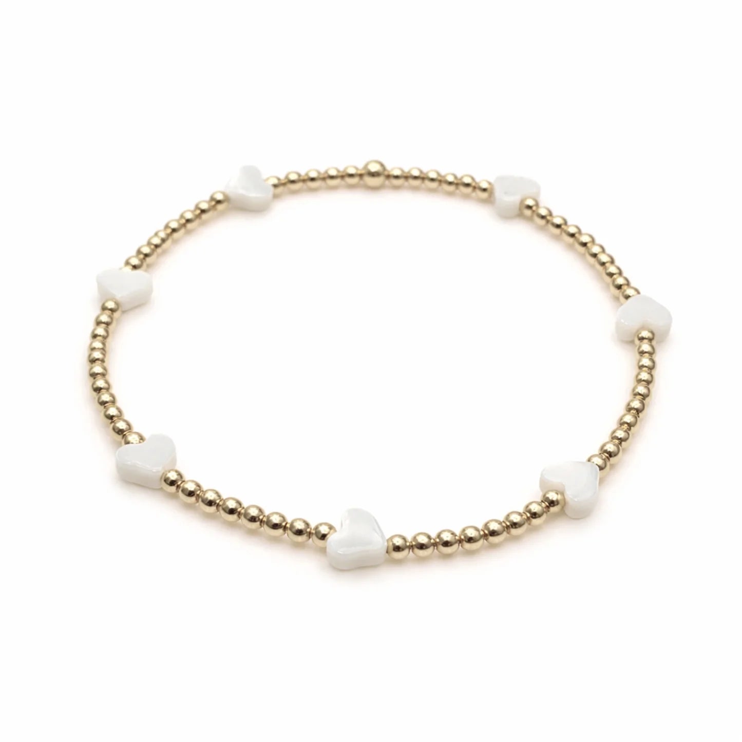Bracelet with gold beads and white stones on a white background