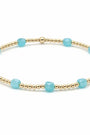 Bracelet with gold beads and turquoise stones on a white background