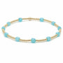 Bracelet with gold beads and turquoise stones on a white background