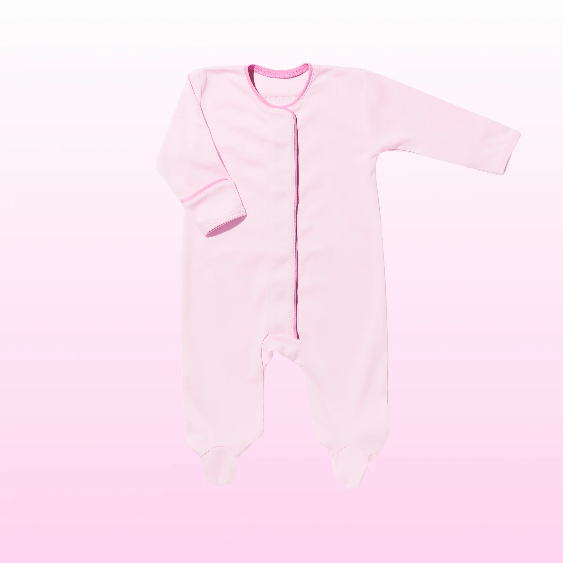 A light pink long-sleeve baby footed sleeper with an asymmetrical zipper, laid flat against a soft pink gradient background.