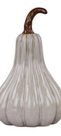 A decorative ceramic pumpkin with a glossy off-white glaze and vertical ribbing, featuring a curved brown stem, isolated on a white background.