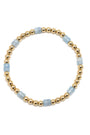 Bracelet with gold beads and light blue stones on a white background