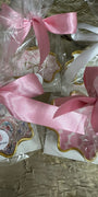 Decorative trinket dishes with pink ribbons and 'KC' branding on a textured surface.