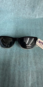 Black sunglasses with a tag on a gray background